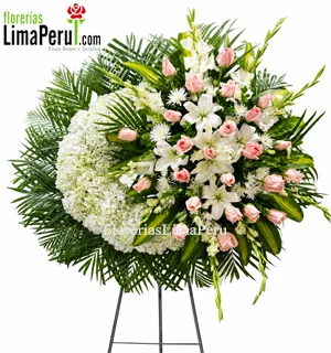 Corona fúnebre rosada para mujer con rosas, lirios y hortensias blancas